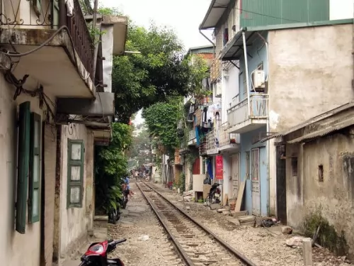 صور - احدى قطارات السكك الحديدية يمر داخل حي سكني صغير